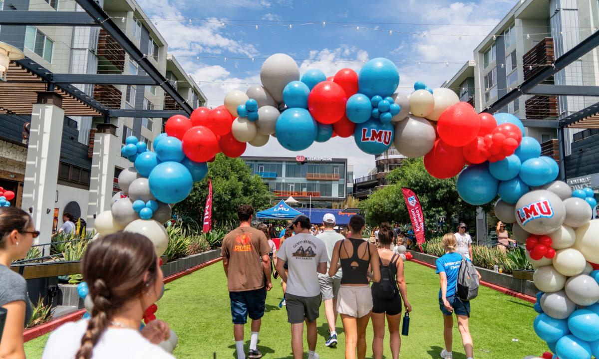LMU balloon archway and students walking underneath
